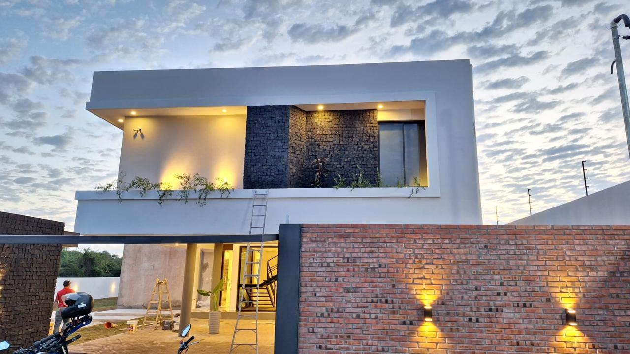 Fachada de la casa NV con apliques de luz sobre el muro de ladrillo